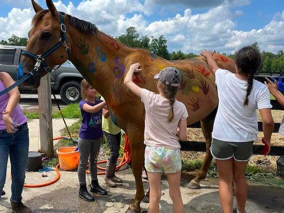 kids hand painting a horse at Redbird Equestrian