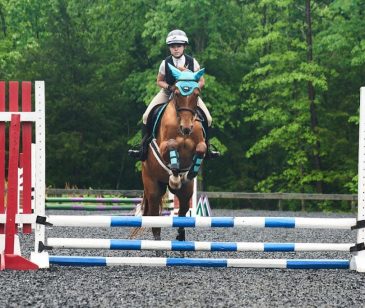 young rider jumping on horseback in an eventing show by redbird equestrian