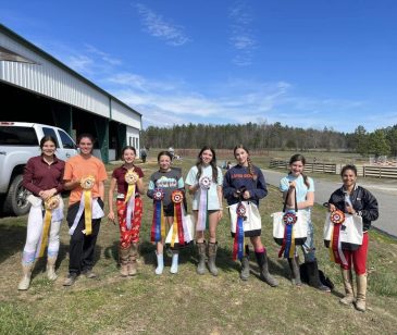 group of teen equestrians showing ribbons in a redbird equestrian show